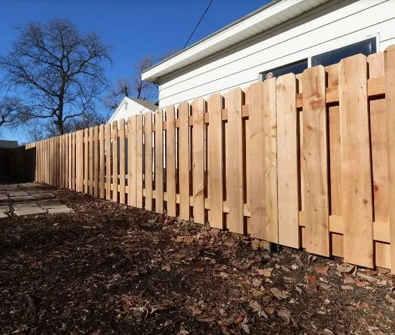 Board-on-board style cedar fence along a modern home