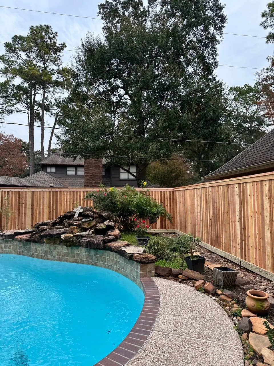 Cedar fence with cap and trim behind a backyard pool in Cypress