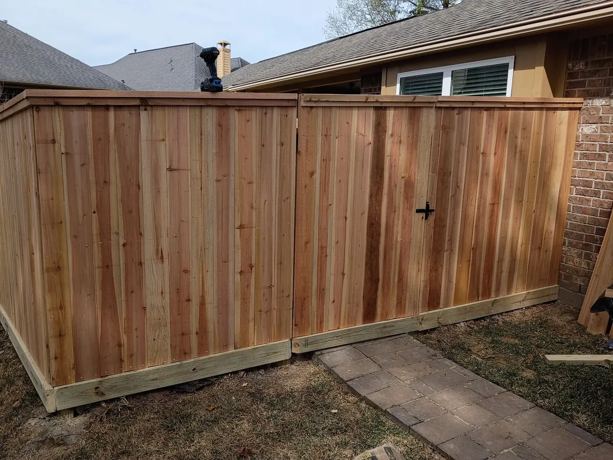 Cedar privacy fence with a walk gate beside a brick home in north Houston
