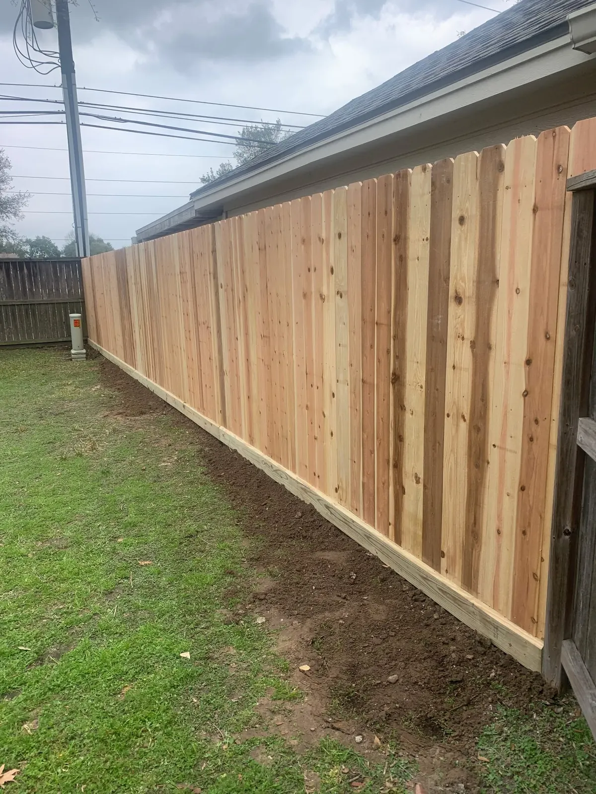Long cedar privacy fence running along the side of a home in north Katy