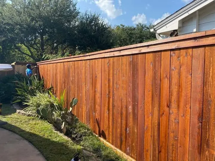 Stained cedar privacy fence with a rich red-brown finish