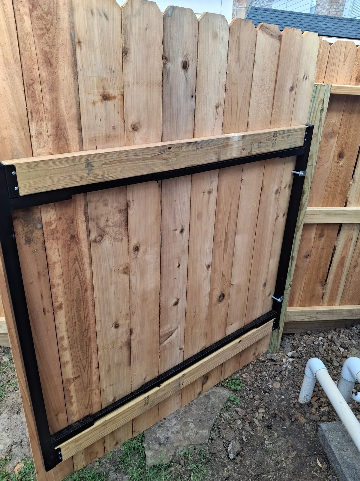 Cedar gate mounted on a black steel frame