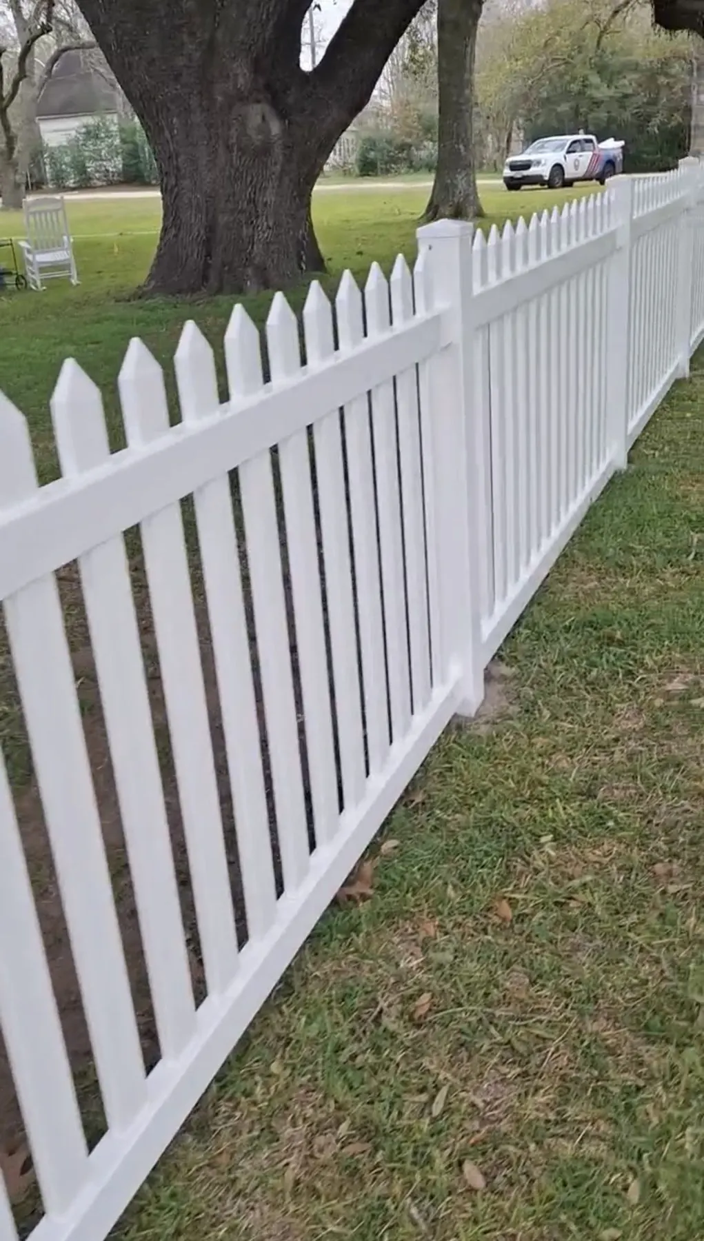 White picket fence between a lawn and a garden in Houston