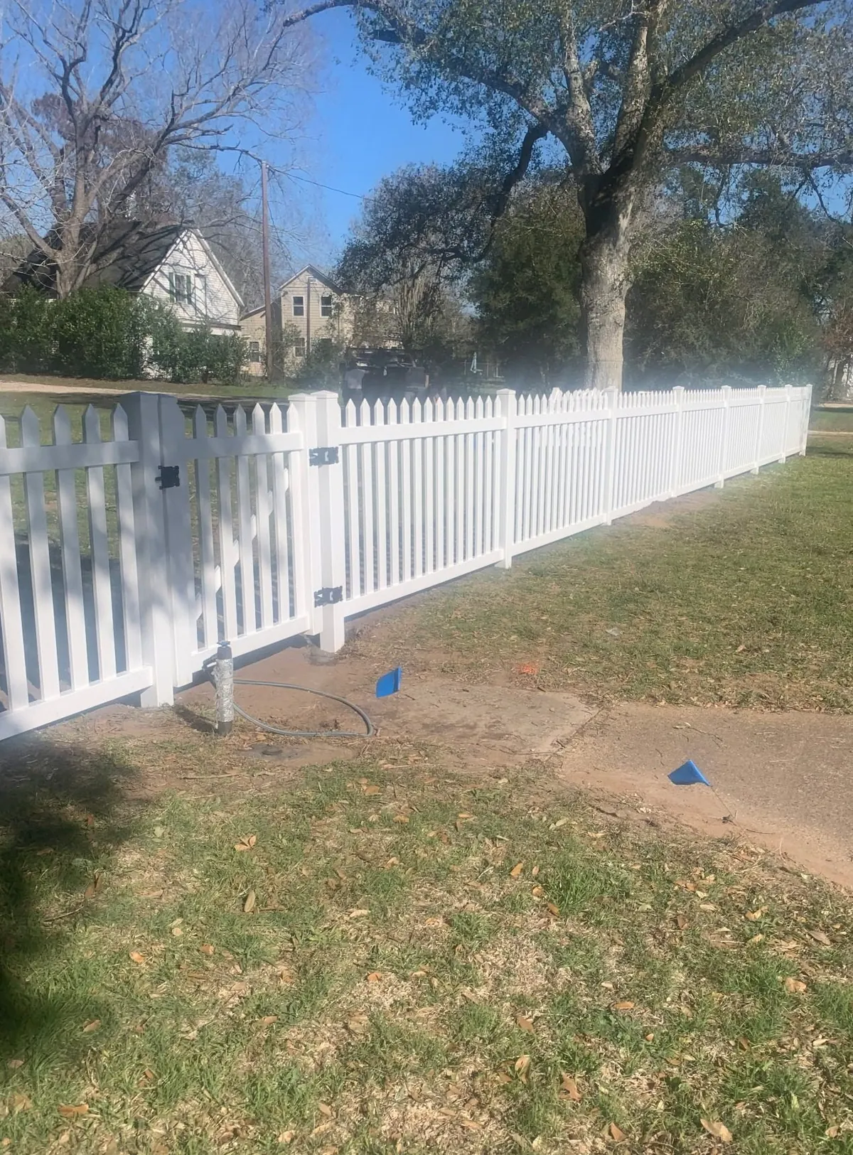 White vinyl picket fence around a yard in Sealy